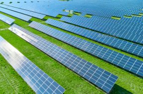 Solar panels producing green renewable energy. Solar power station in the field with green grass.