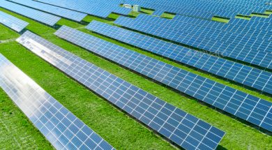 Solar panels producing green renewable energy. Solar power station in the field with green grass.